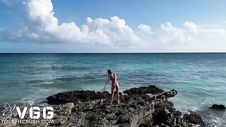 A petite and sexy girl is playing on the naked beach, showcasing her erotic charm