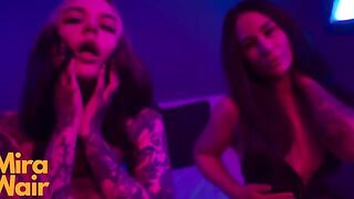 Two girls in dresses have fun with a man using a huge toy together
