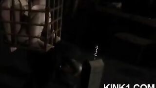 A slave in a cage is at the mercy of his master and fulfills all his orders