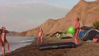 A man plays badminton naked with a girl on the beach