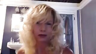 A mature woman caresses herself in the bathroom, using a vibrator for added pleasure