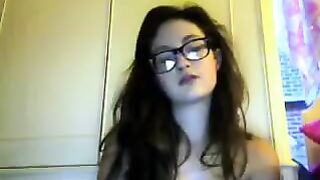 A cute girl in glasses has a video chat and undresses