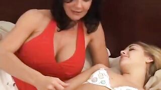 Two girls are having fun with a strapon in the bedroom