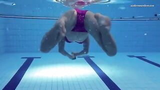 A beautiful naked girl is swimming in the pool with a big ass