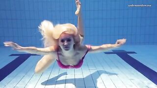 A beautiful naked girl is swimming in the pool with a big ass
