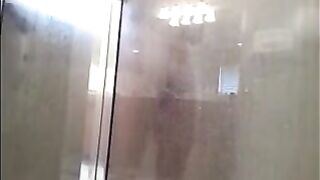 A man washes himself in the shower, but he does not know that he is being watched