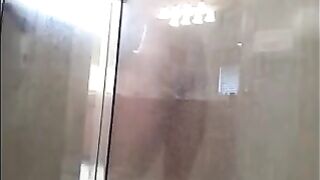 A man washes himself in the shower, but he does not know that he is being watched