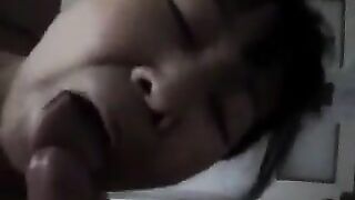 An adult Chinese woman practices her blowjob skills on him in a steamy bedroom scene