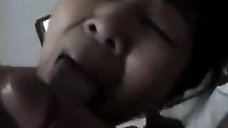 An adult Chinese woman practices her blowjob skills on him in a steamy bedroom scene