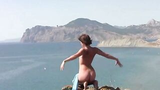 Nude beauty poses on the sandy coast of the sea