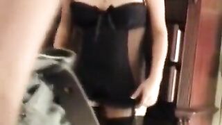 A husband is having fun with his wife in a corset in the bedroom