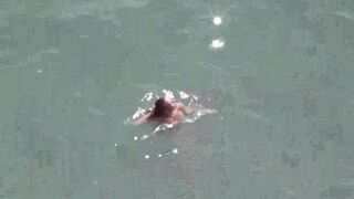 A pair of naturists sunbathing completely naked on the sea coast