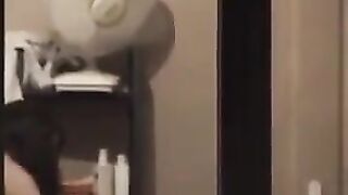 He admires his reflection in the mirror completely naked