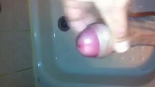 The kid caresses his cock in the shower with his hand