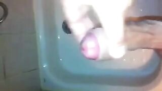 The kid caresses his cock in the shower with his hand