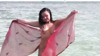 A woman takes a sea bath without any clothes on