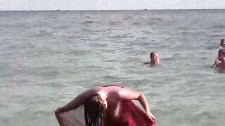 A woman takes a sea bath without any clothes on