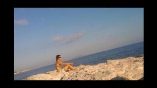 A girl sunbathes completely naked on the beach