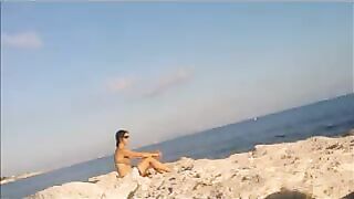 A girl sunbathes completely naked on the beach