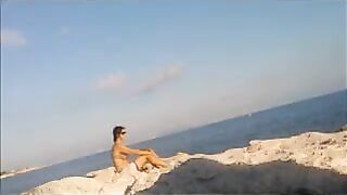 A girl sunbathes completely naked on the beach