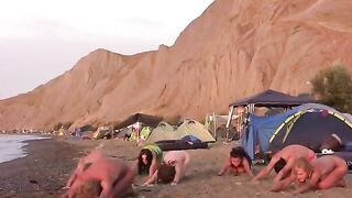 A group of naked people are playing volleyball together