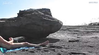 A girl undresses on the beach and masturbates with her hands