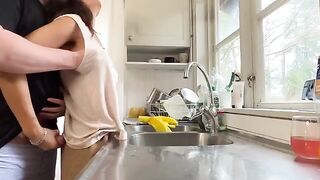 A mature woman with big tits is being fucked from behind in the kitchen